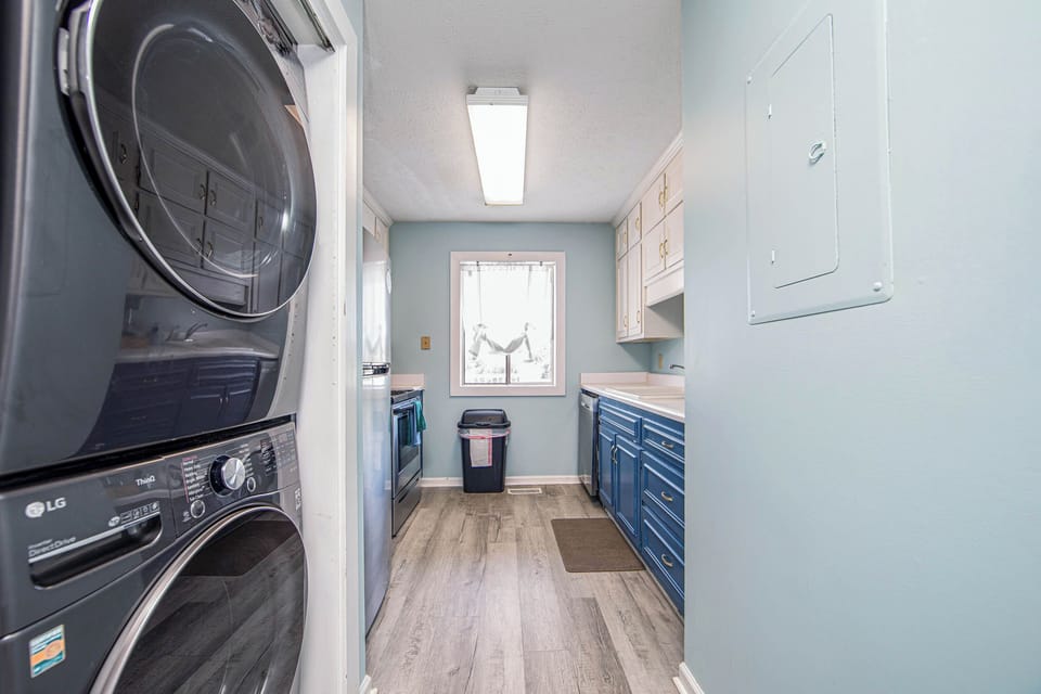 Bright laundry room with full-size washer/dryer and ample storage