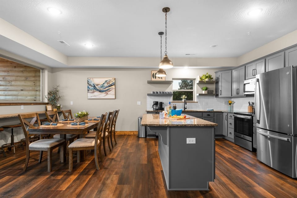 Fully stocked kitchen with island seating and full-size stainless appliances.