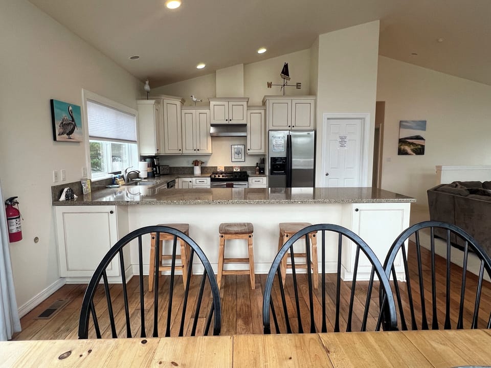 Your fully equipped kitchen awaits with modern appliances, ample counter space, and charming rustic wood ceilings. The loft sleeping area above adds cozy character to this inviting open layout.