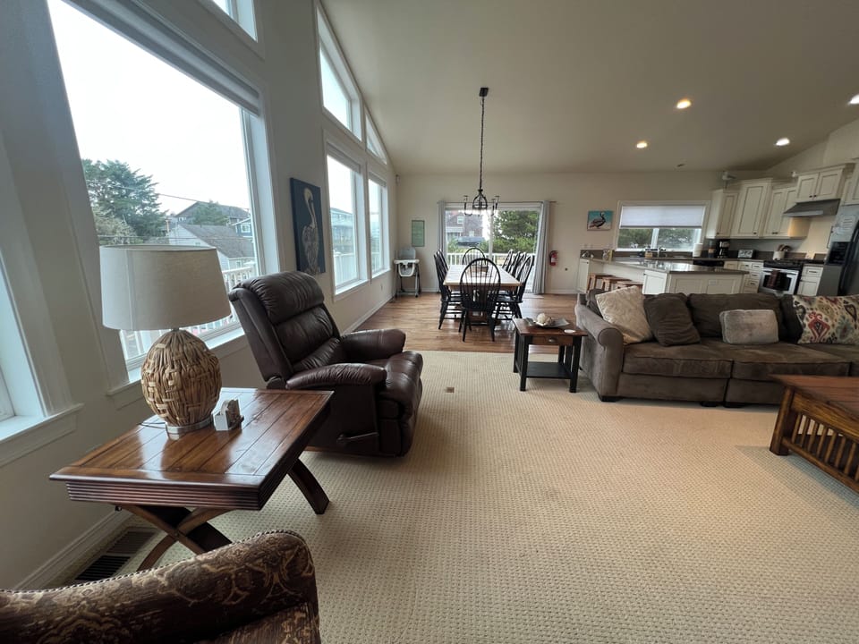 Spacious open-plan living area seamlessly connects the kitchen and living room, with inviting leather seating, polished floors, and abundant natural light to brighten your stay.
