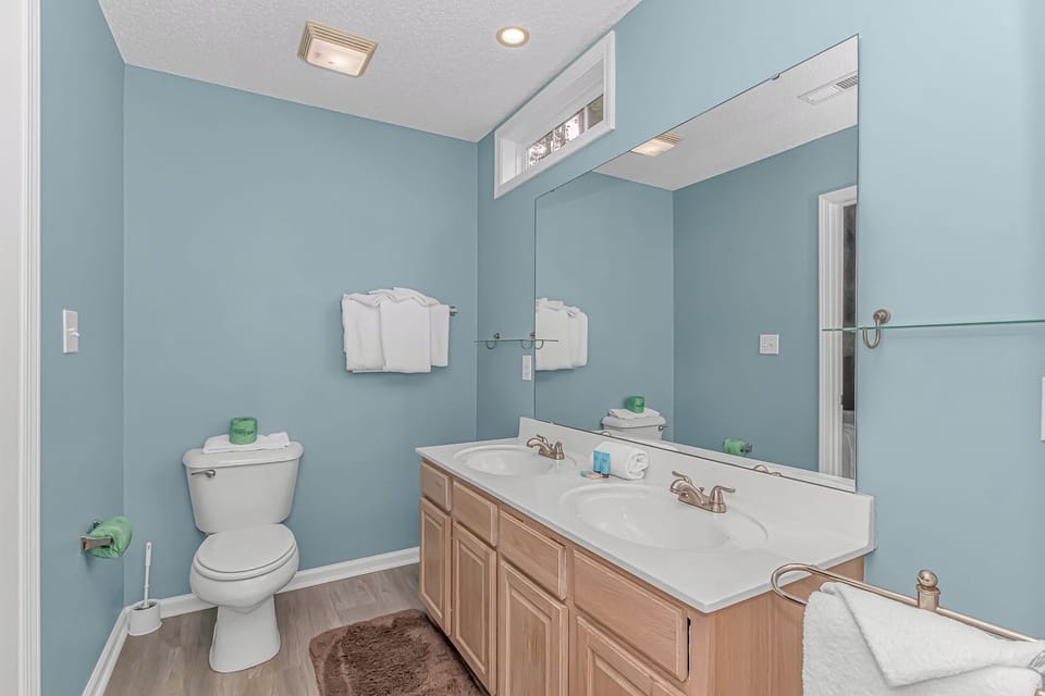 Primary ensuite bathroom with double vanity and toilet.