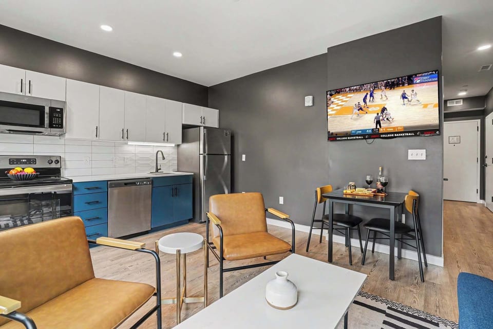 
Bright open floor living space featuring a smart flat-screen TV and designer furnishings. Connects to the dining area and kitchen.