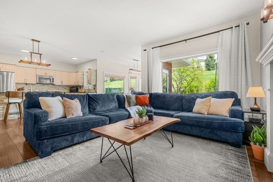 Main floor living room with a gas-lit fireplace, 65` Smart TV, board games and an oversized sectional.