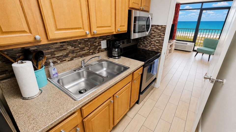 Cook with ease in the fully stocked kitchen featuring a full-size stove, microwave, and full refrigerator/freezer, along with all the essentials needed for your stay. Whether you’re preparing breakfast before the beach or a relaxing dinner after a day in 