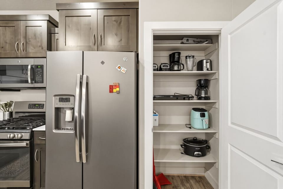 Kitchen pantry with small appliances, open shelving, and extra storage space.
