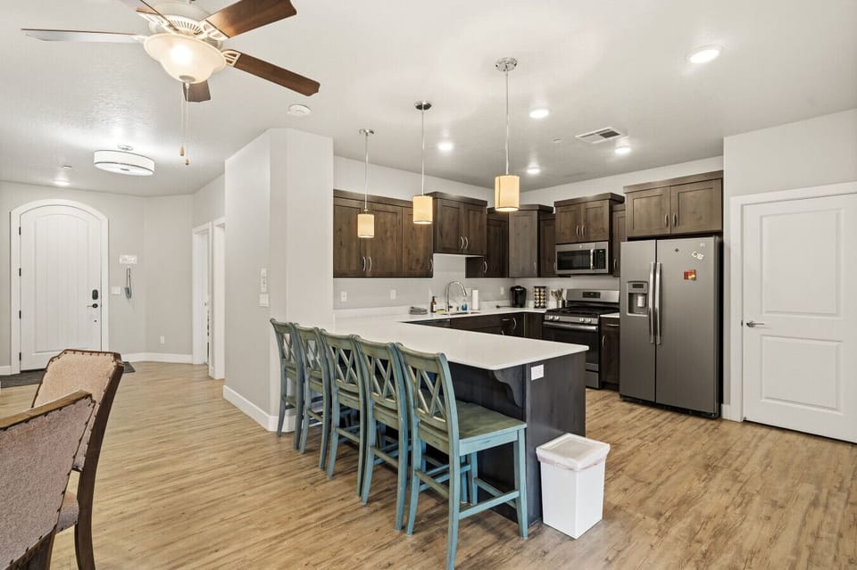 Kitchen with large island, bar seating, full appliances, and open layout.