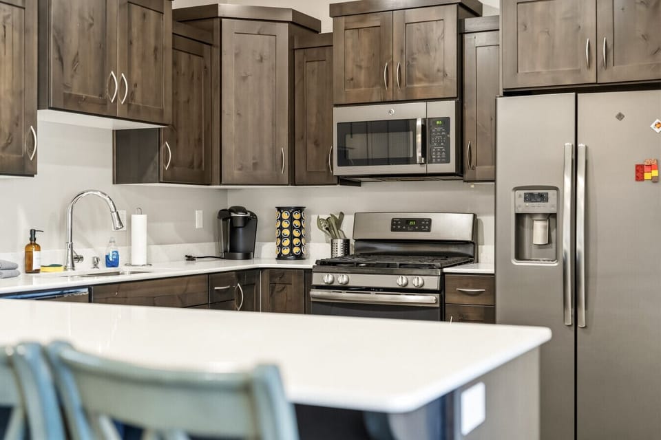 Kitchen with wood cabinets, stainless steel appliances, island counter, and modern finishes.