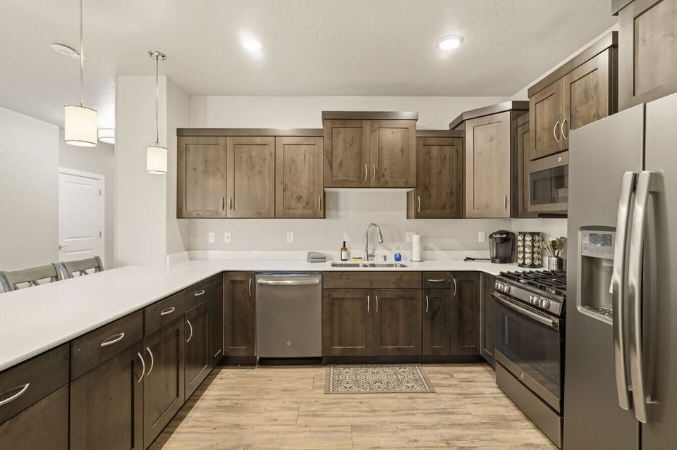Kitchen with large island, full appliances, wood cabinets, and modern finishes.