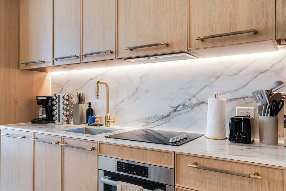 A gourmet chef’s kitchen featuring seamless under-cabinet lighting and high-end stainless steel appliances.