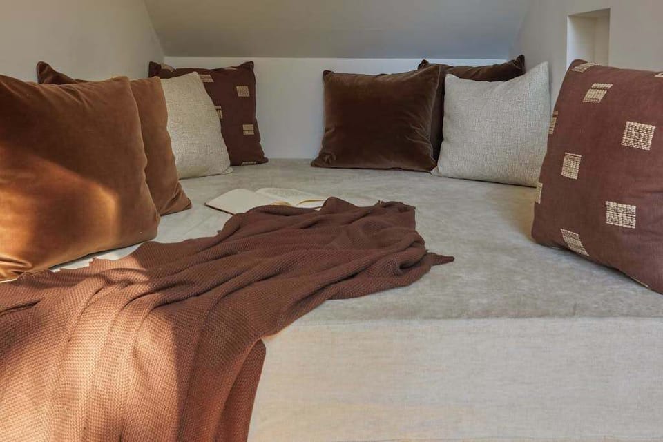 This cozy nook is your perfect retreat for peaceful moments, surrounded by plush pillows and natural light, inviting relaxation and introspection.