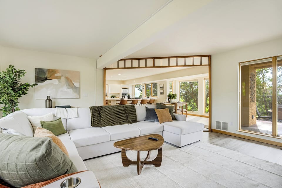 The living room includes a gas fireplace, a large 75” Samsung Smart TV, and sliding door access to a west-facing balcony with mountain views.