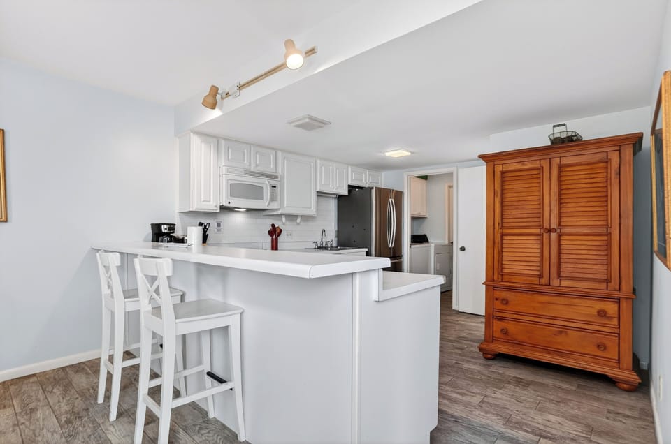 Bright kitchen with bar seating, stainless appliances, and easy flow into the main living area.