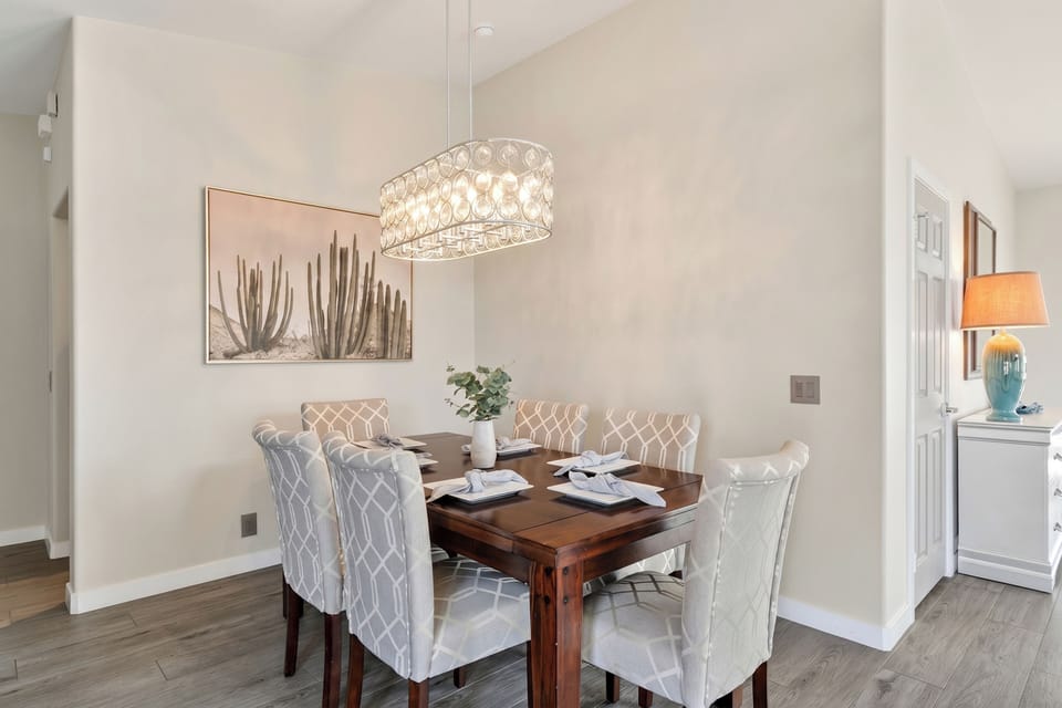 Formal dining area featuring a rich wood table, beautifully upholstered high-back chairs, and a glamorous crystal chandelier.
