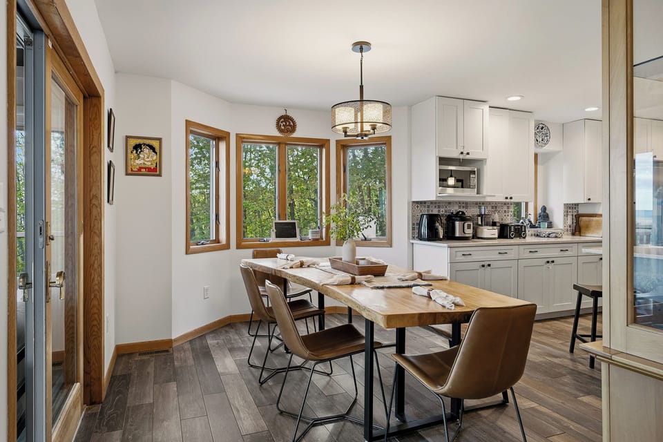 Dining with a view—gather around the wood table with sweeping valley and deck views just beyond the doors.