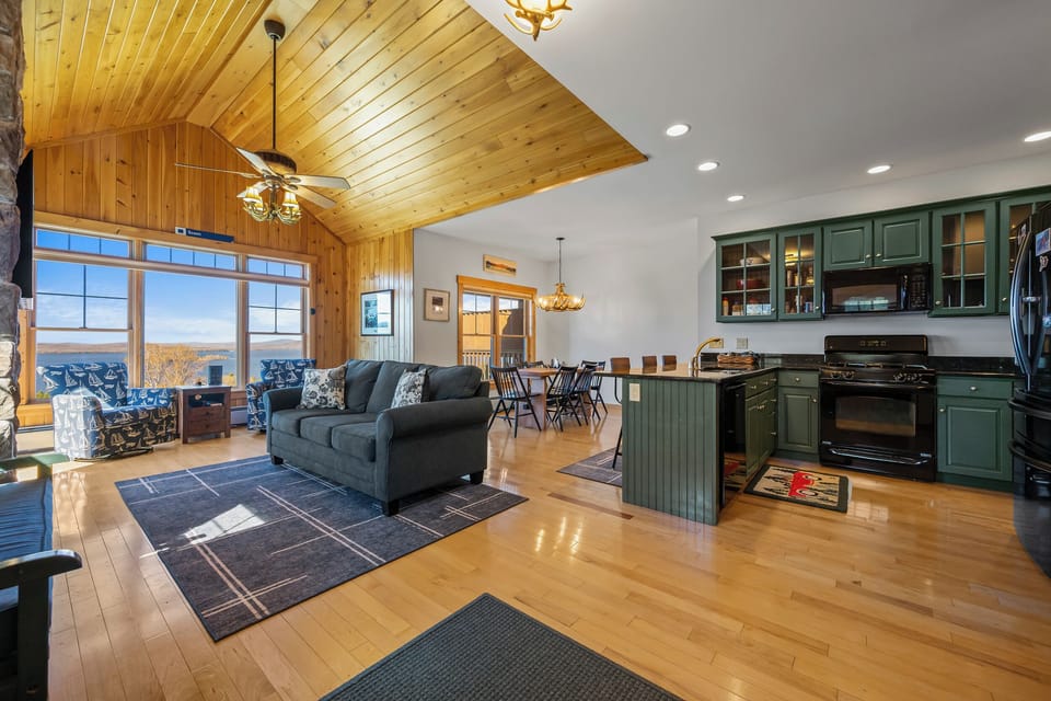 Living room, kitchen, & dining room with lake views