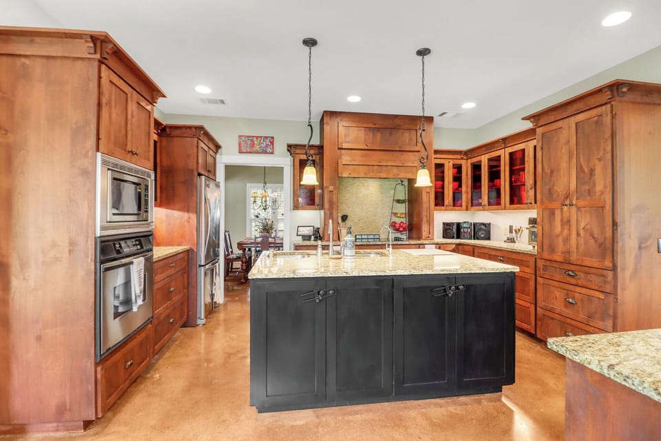 Cook in your spacious gourmet kitchen with rich wood cabinets, granite counters, and a grand center island perfect for meal prep.
