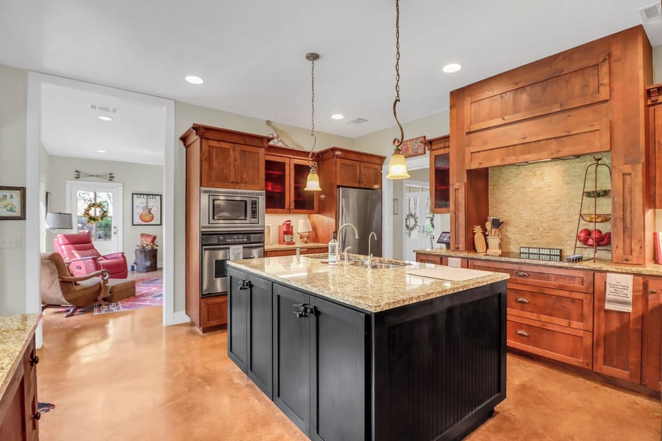 You'll love cooking in this stunning kitchen with warm wood cabinets, granite island, and stainless appliances.