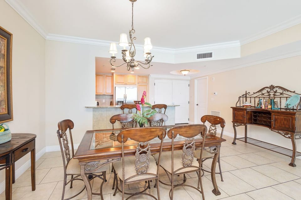 Gather around this elegant dining space, where an ornate chandelier sets the tone for memorable meals with your group. The open layout flows seamlessly to the kitchen, making entertaining effortless.