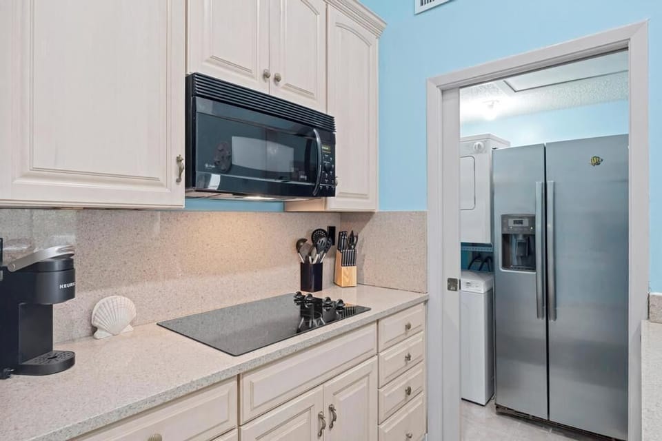 Well-equipped kitchen w/ ample cabinetry, stainless steel appliances & a mounted TV.