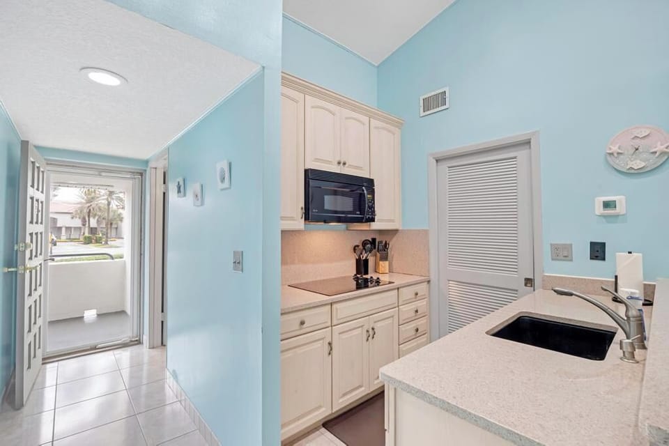Stylish kitchen corner w/ stainless steel fridge & crisp white upper cabinets.