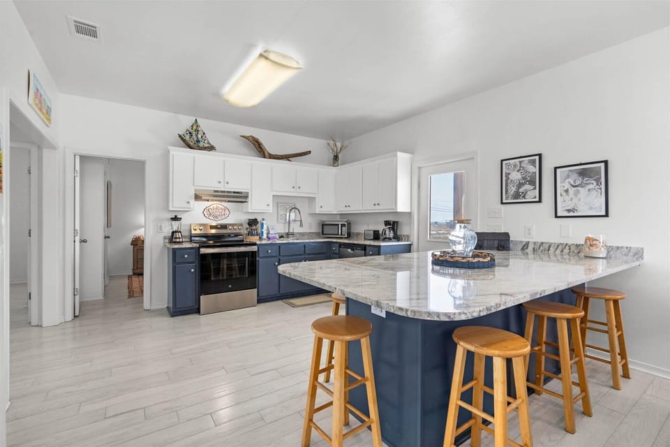 Your spacious kitchen features modern appliances, granite countertops, and a breakfast bar perfect for morning coffee or casual dining.