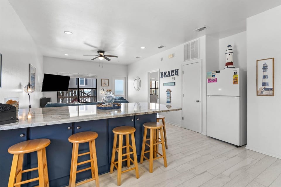 Your spacious kitchen features nautical charm with a breakfast bar, coastal decor, and everything needed for memorable meals together.
