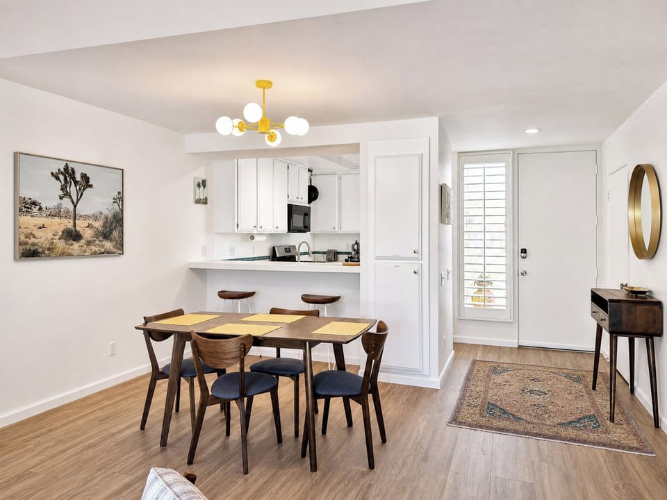 Step into your bright, open living space with stylish mid-century furnishings, a fully equipped kitchen, and warm wood-look flooring that invites you to settle in and relax.