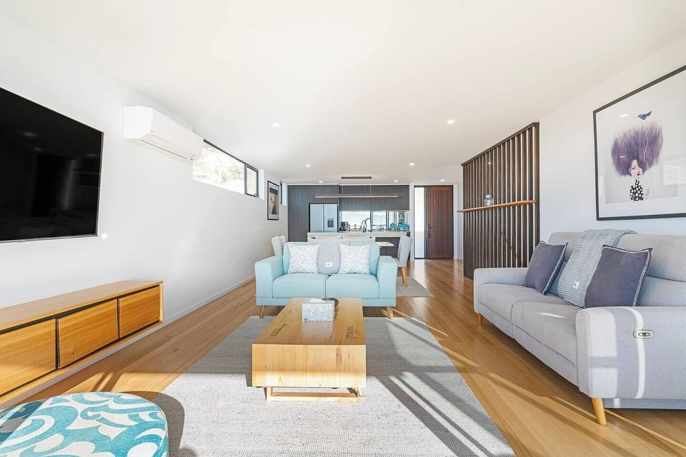 The open-plan layout brings together the lounge, dining, and kitchen spaces in one light-filled setting designed for easy conversation, shared meals, and relaxed evenings.
