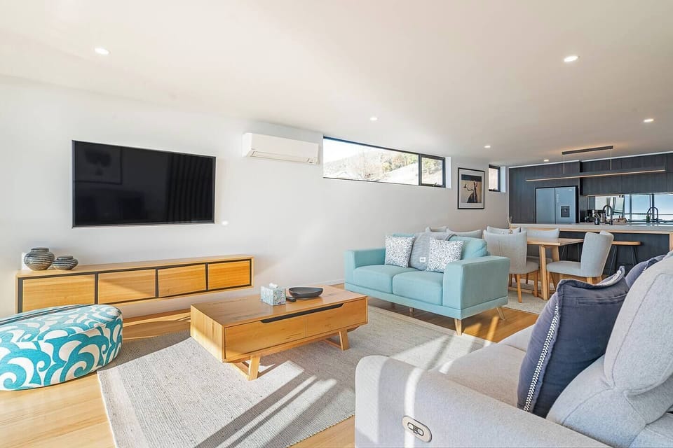 Sink into the sunlit living area where soft contemporary styling, warm finishes, and sweeping river views create an inviting place to unwind after a day exploring MONA and Hobart’s waterfront.