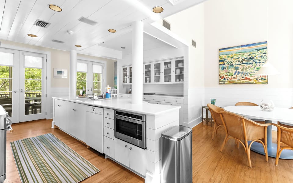 Step into your gourmet kitchen with gleaming white cabinetry, modern appliances, and hardwood floors. Natural light pours through French doors, while the breakfast nook invites leisurely morning coffee.