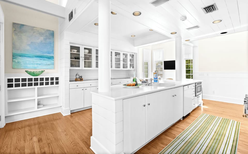 Your bright, spacious kitchen features crisp white cabinetry, gleaming countertops, and a large center island perfect for meal prep or gathering with loved ones.