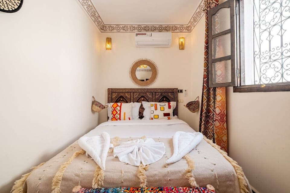 Chambre élégante avec salle de bain privée, climatisation, TV et minibar.