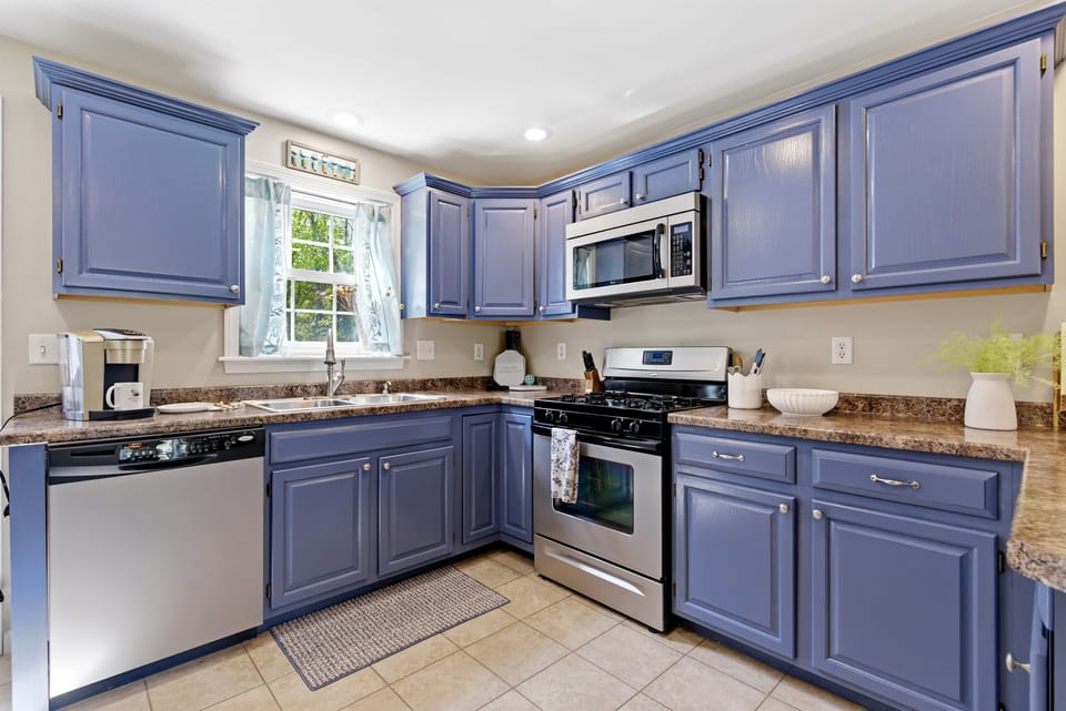 A charming kitchen featuring beautiful blue cabinetry, creating a fresh and inviting space for cooking and gathering.