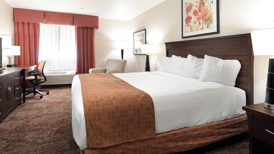 Unwind on a plush king bed under warm lamplight.
