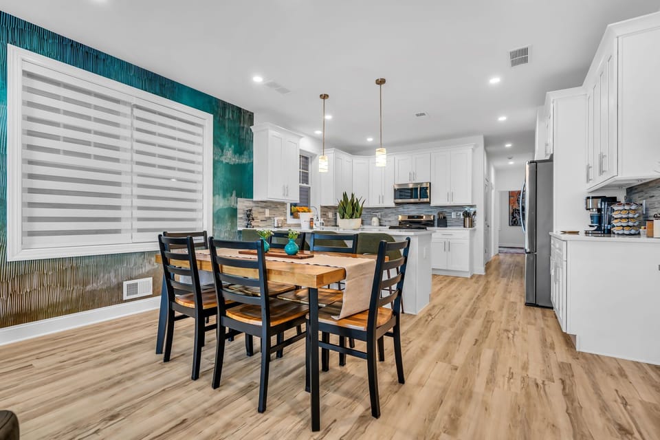 Bright modern kitchen with island, dining space, and stylish accent wall