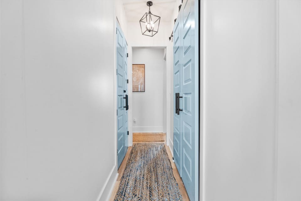 Bright hallway with coastal-inspired décor, modern finishes, and easy access to spacious guest bedrooms and bathrooms.