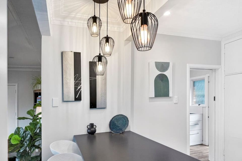 Gather around your sleek dining table beneath statement pendant lights—the perfect spot for family dinners with a view.