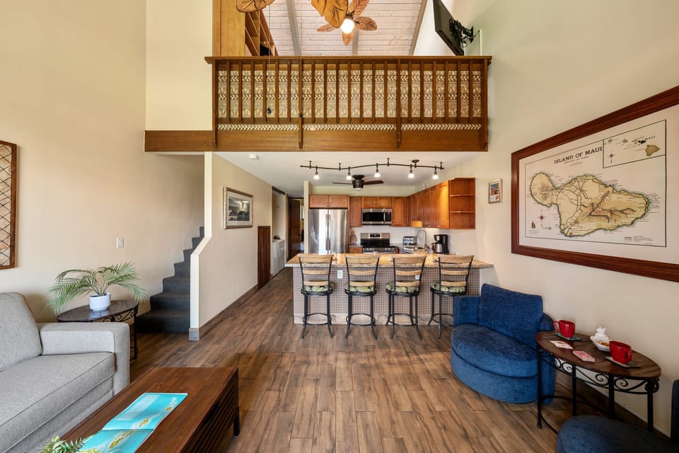 Open living and dining area with breakfast bar and loft overhead.
