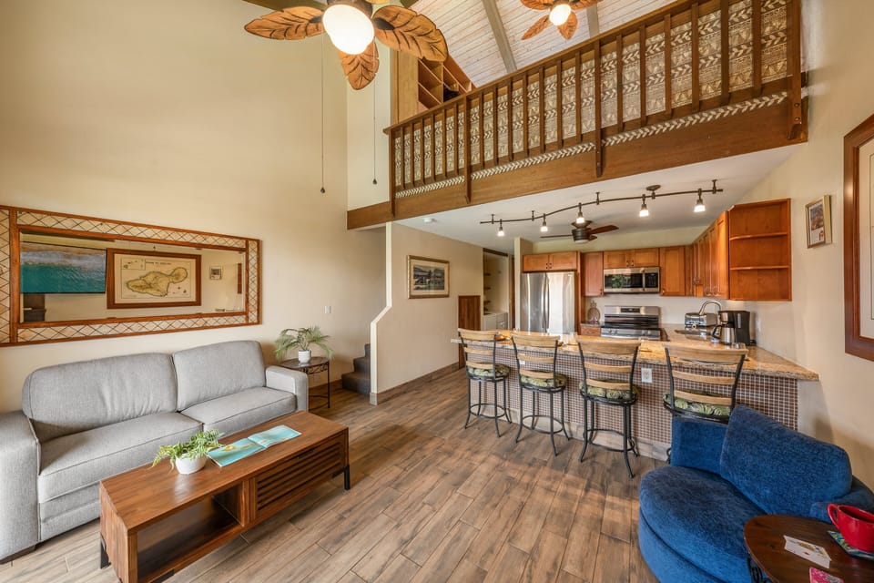Bright main living space with loft above and open kitchen layout.