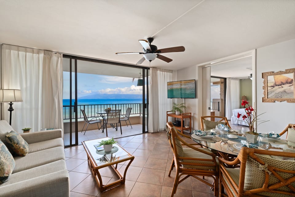 Bright, spacious living space with comfortable seating, dining area, and direct access to the oceanfront balcony.