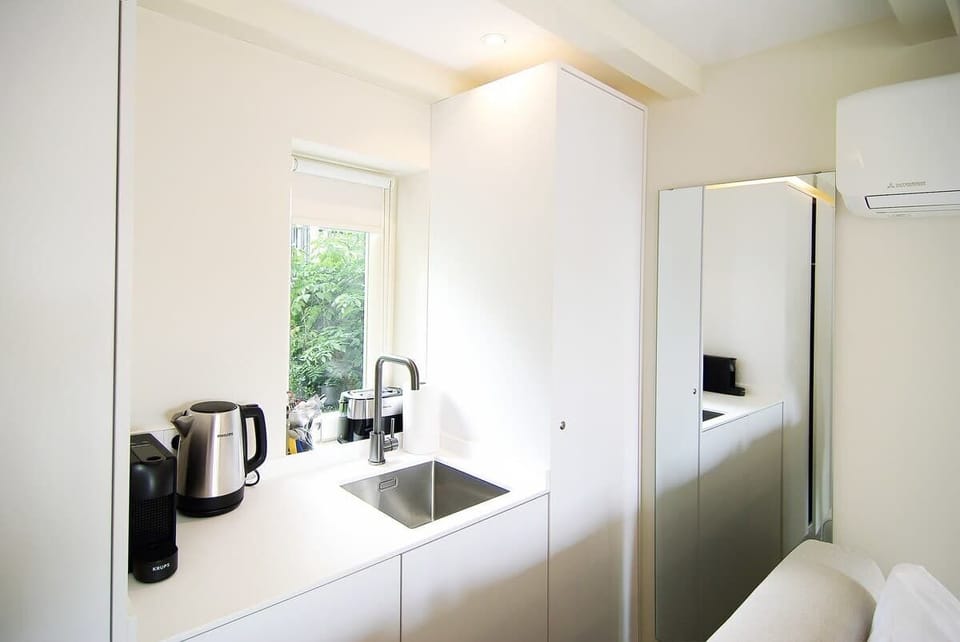 Compact kitchenette with coffee, tea, a sink and minifridge for a comfortable canal-side stay.