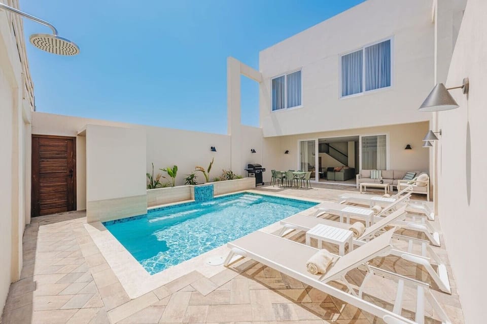 Modern villa with private pool, sunny patio, and relaxing outdoor lounge area.