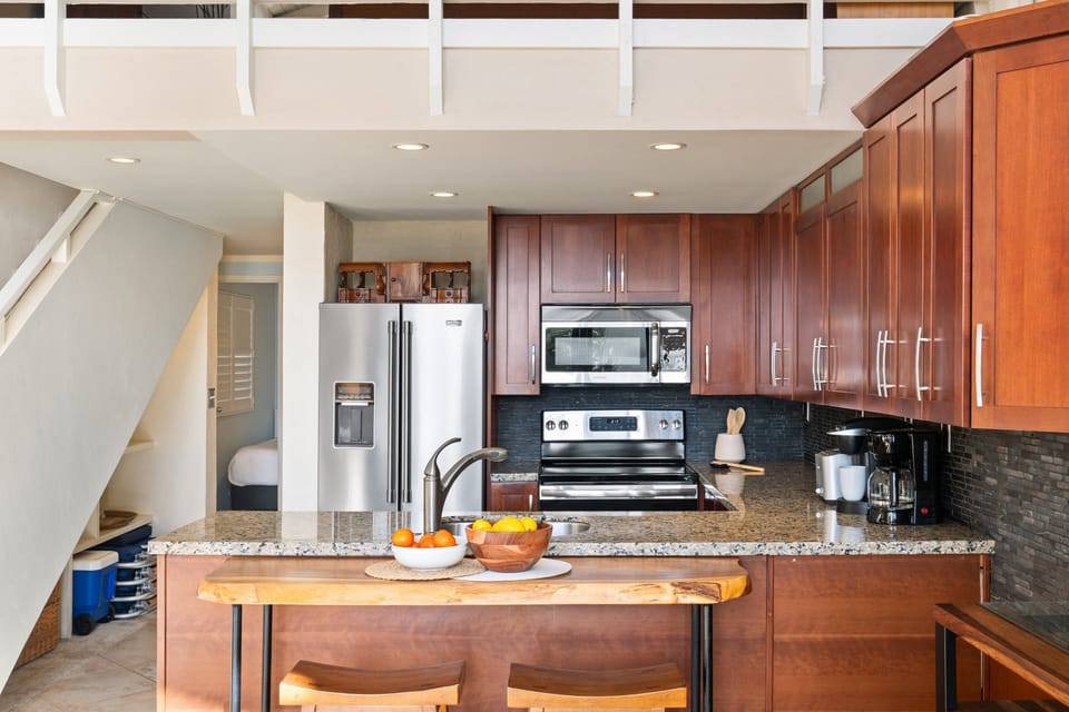 Fully equipped kitchen with granite counters and modern appliances.