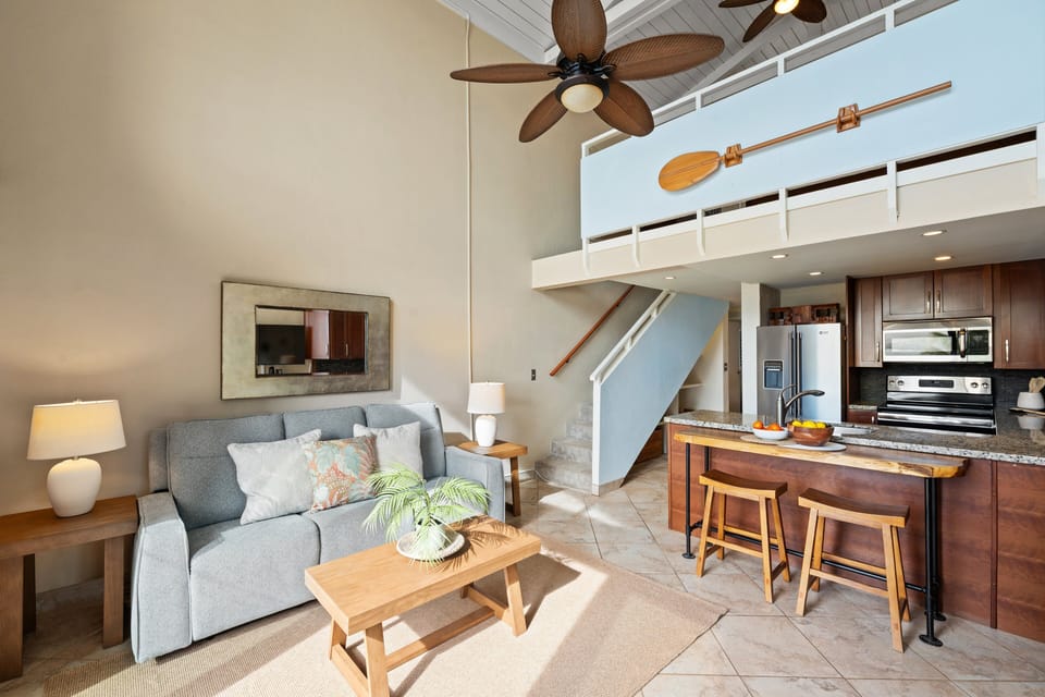 Open living and kitchen area with island seating and loft-style layout.