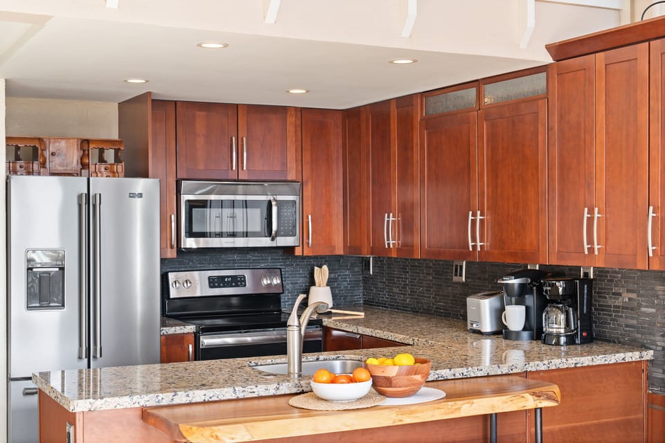 Fully equipped kitchen with modern appliances and breakfast bar seating.