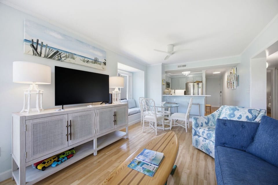 Bright open-concept living and dining space with fresh coastal décor and comfortable seating