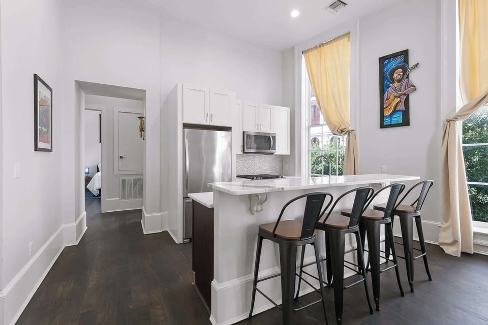 Sleek kitchen with granite island seating, tall windows, and modern finishes perfect for gathering before exploring the city.