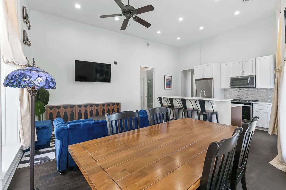Sun-filled suite featuring 3D artwork by Patrick Henry and real instruments honoring New Orleans blues roots. Relax beside tall windows or gather around the beautiful wood dining table where modern comforts meet soulful local artistry.
