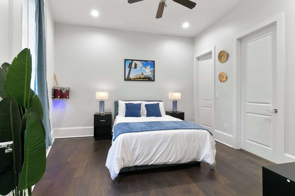 Cozy queen suite featuring iconic Herb Leonard photography, crisp linens, modern furnishings, and a relaxing boutique atmosphere inspired by New Orleans music culture.