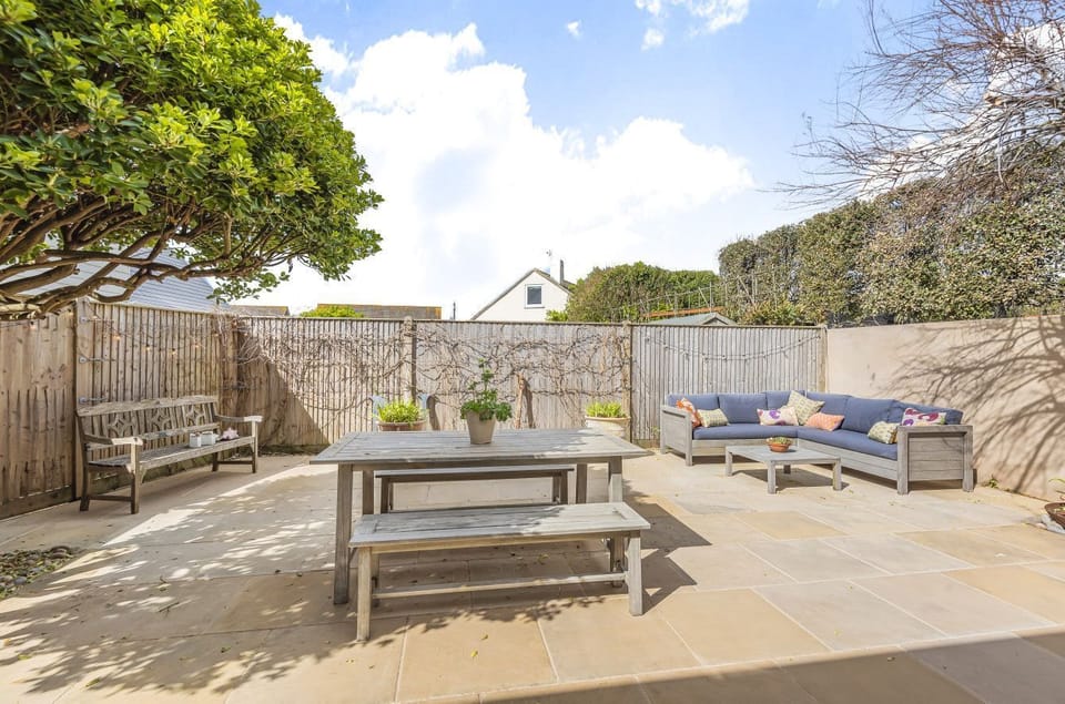 The rear garden is a sun trap with dining furniture and relaxed seating